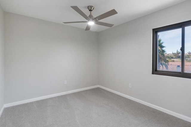 carpeted spare room featuring ceiling fan