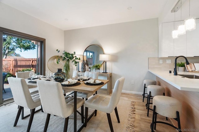 dining area with sink and light hardwood / wood-style floors