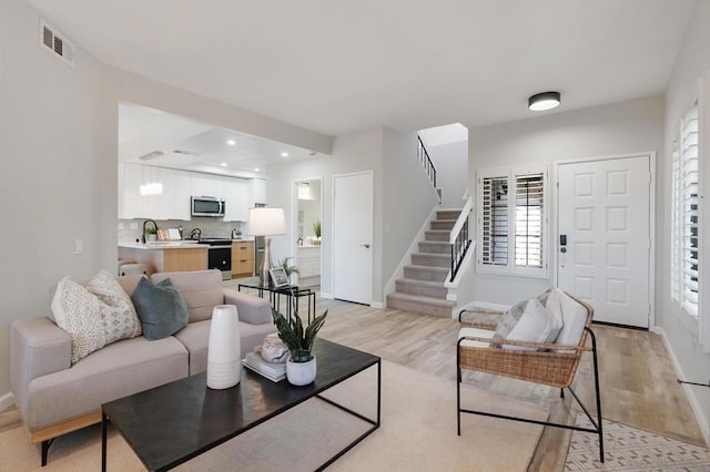 living room with sink and light hardwood / wood-style floors