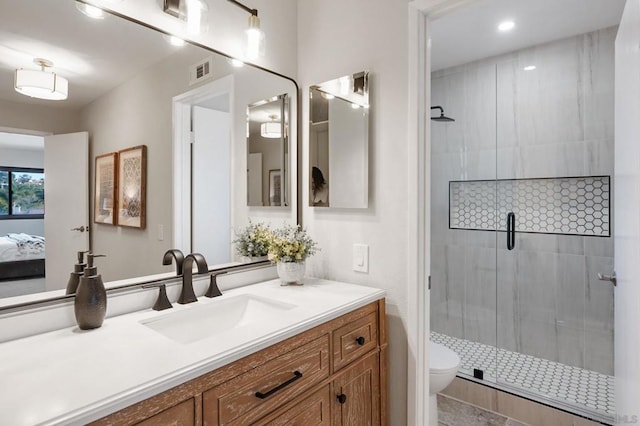 bathroom with vanity, a shower with door, and toilet