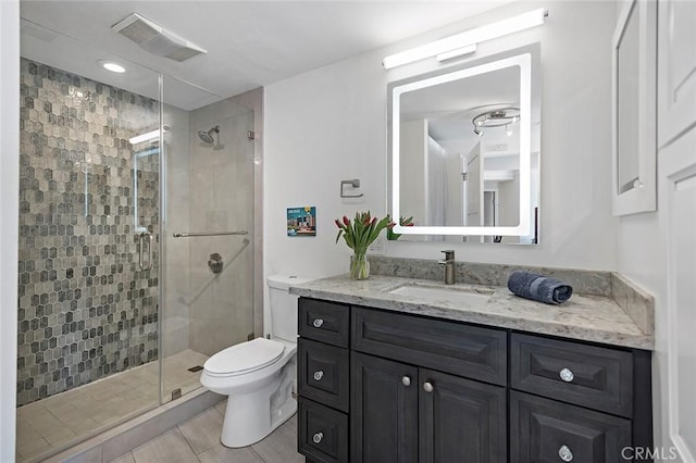 bathroom with vanity, toilet, and a shower with door