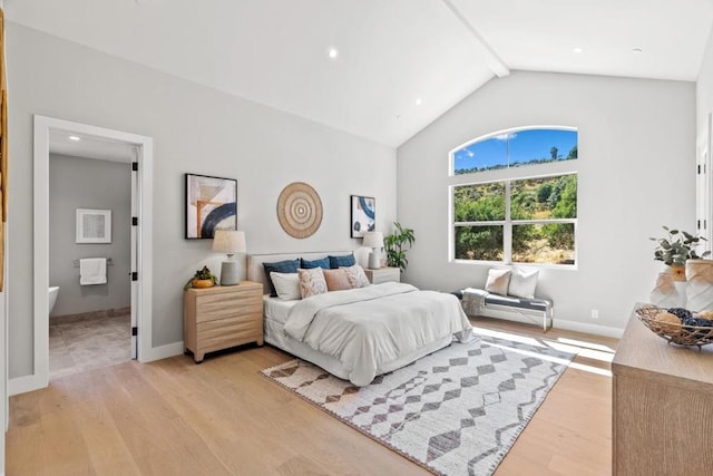 bedroom featuring lofted ceiling, ensuite bath, and light hardwood / wood-style flooring