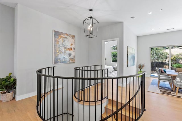 hall featuring an inviting chandelier and light hardwood / wood-style flooring