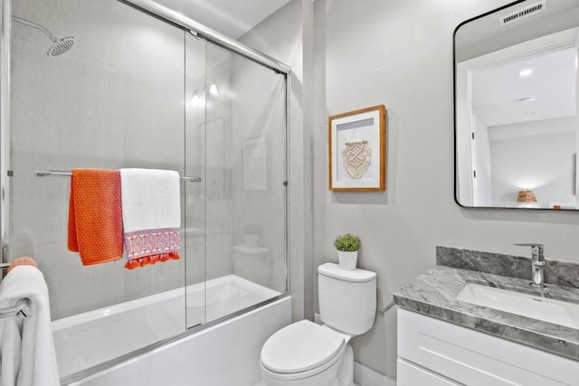 full bathroom with vanity, shower / bath combination with glass door, and toilet