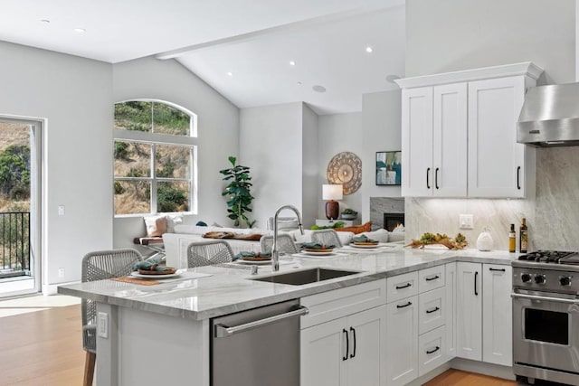 kitchen featuring sink, light stone countertops, white cabinets, and appliances with stainless steel finishes