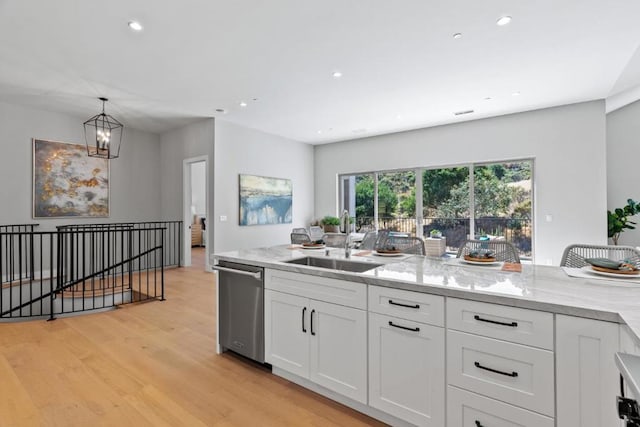 kitchen with white cabinetry, sink, light stone counters, and dishwasher