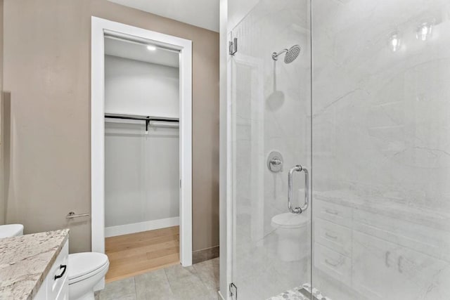 bathroom featuring walk in shower, vanity, and toilet