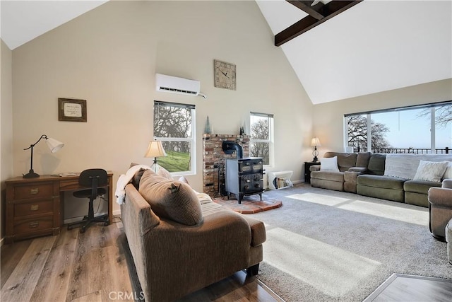 living room with plenty of natural light, high vaulted ceiling, a wall mounted AC, and a wood stove