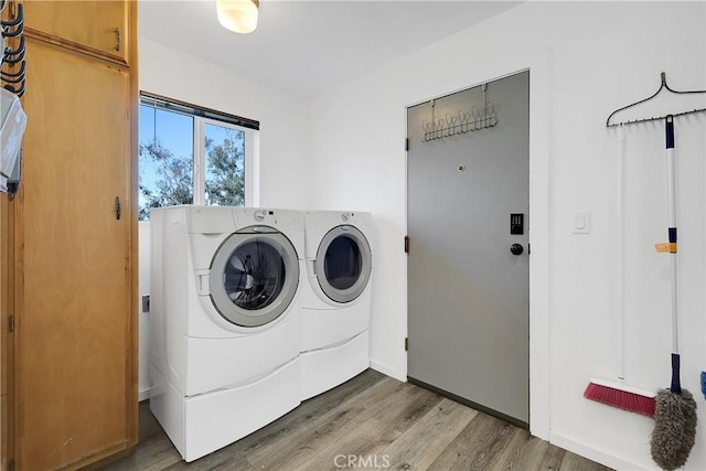 laundry room featuring hardwood / wood-style floors and washing machine and clothes dryer