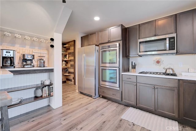 kitchen featuring appliances with stainless steel finishes, dark brown cabinetry, and light hardwood / wood-style flooring