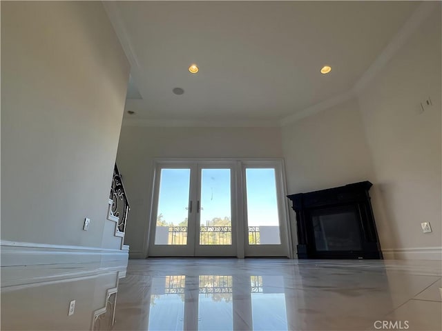 unfurnished living room featuring crown molding and french doors