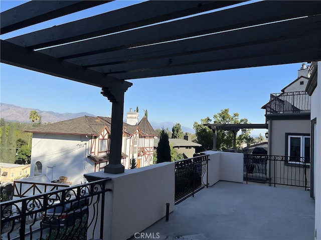 view of patio featuring a balcony, a mountain view, and a pergola