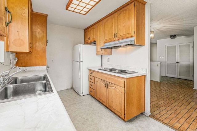 kitchen featuring white refrigerator, sink, and stainless steel gas cooktop