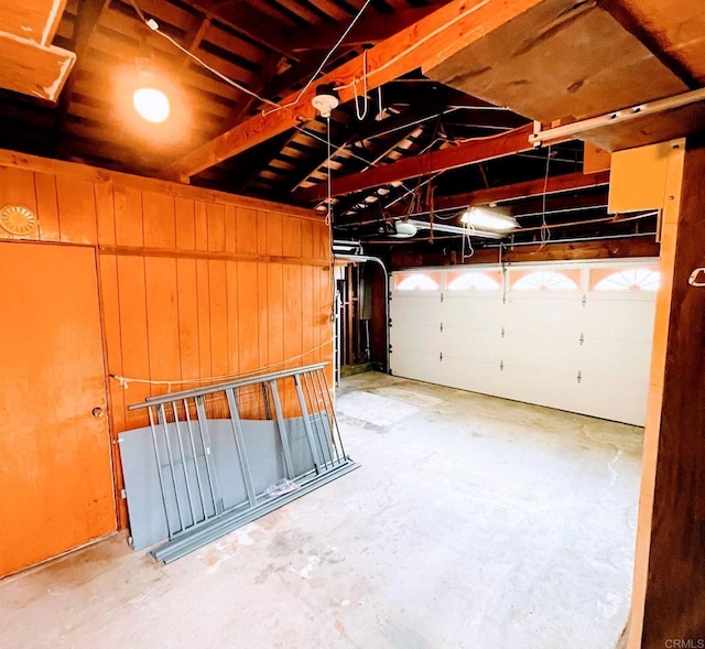 garage featuring a garage door opener and wood walls