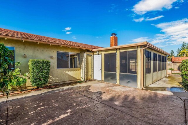 rear view of house with a patio and a sunroom