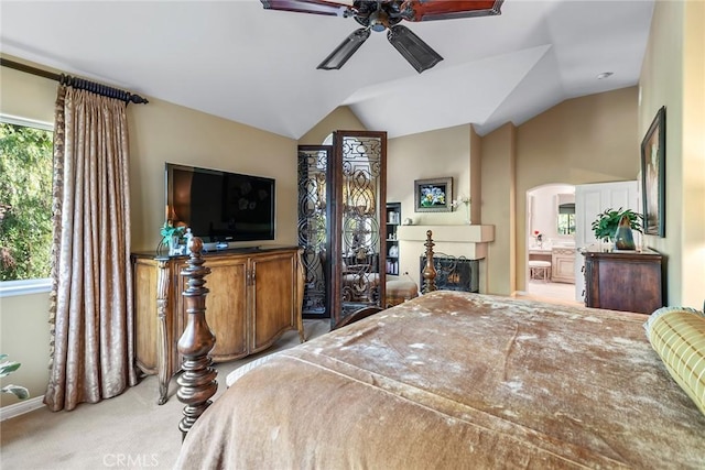 bedroom featuring multiple windows, lofted ceiling, connected bathroom, and ceiling fan