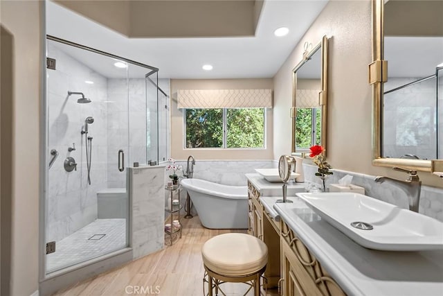 bathroom featuring wood-type flooring, independent shower and bath, and vanity