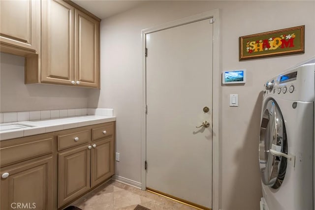 clothes washing area featuring washer / dryer and cabinet space
