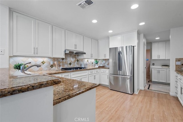 kitchen featuring appliances with stainless steel finishes, under cabinet range hood, white cabinetry, and visible vents