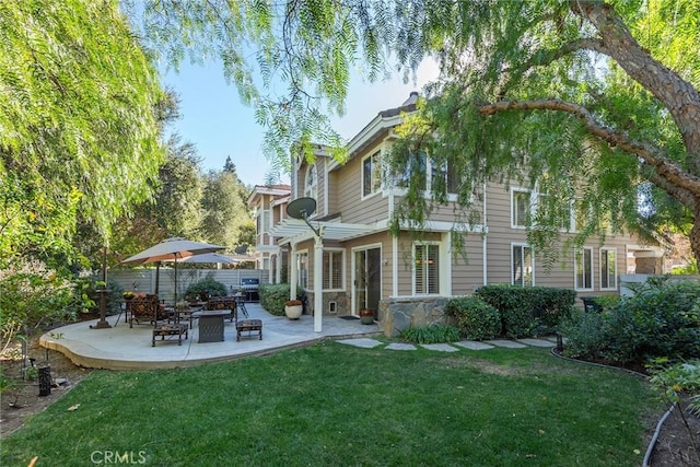 back of house with a lawn and a patio area