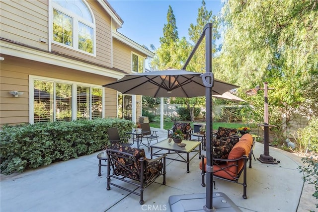 view of patio with fence and an outdoor living space with a fire pit