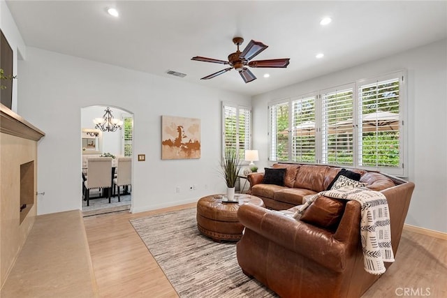 living area with light wood-style floors, ceiling fan with notable chandelier, recessed lighting, baseboards, and visible vents