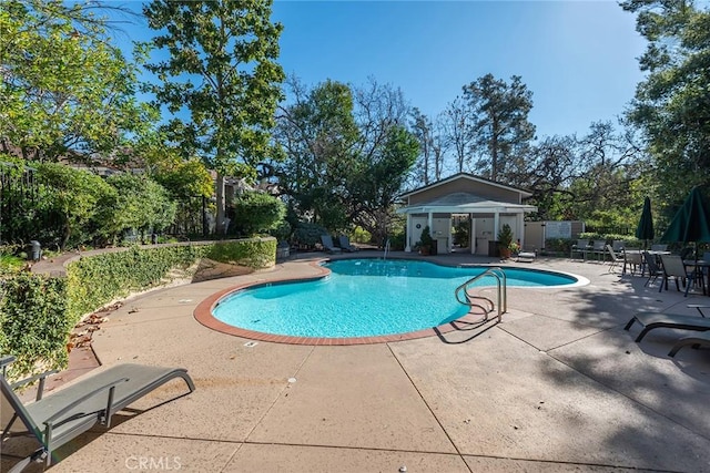 pool with a patio and fence