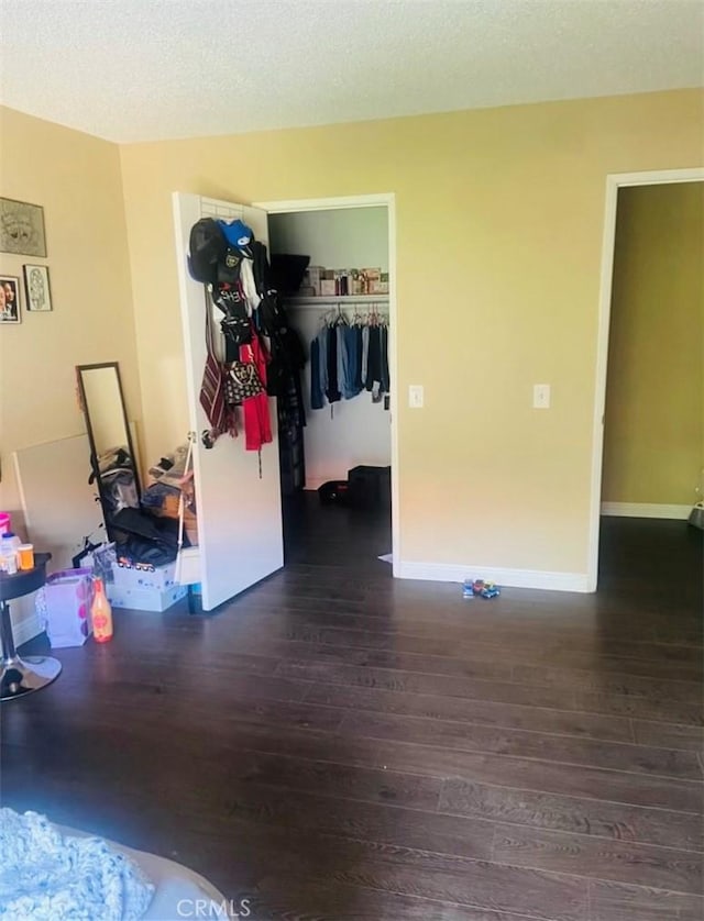 interior space with dark wood-type flooring, a closet, and a textured ceiling