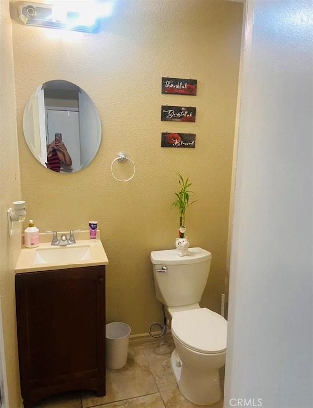 bathroom featuring vanity, tile patterned flooring, and toilet