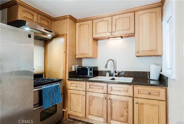 kitchen with stainless steel appliances, sink, light brown cabinets, and dark stone countertops