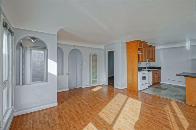 kitchen with sink, white gas stove, and light hardwood / wood-style floors