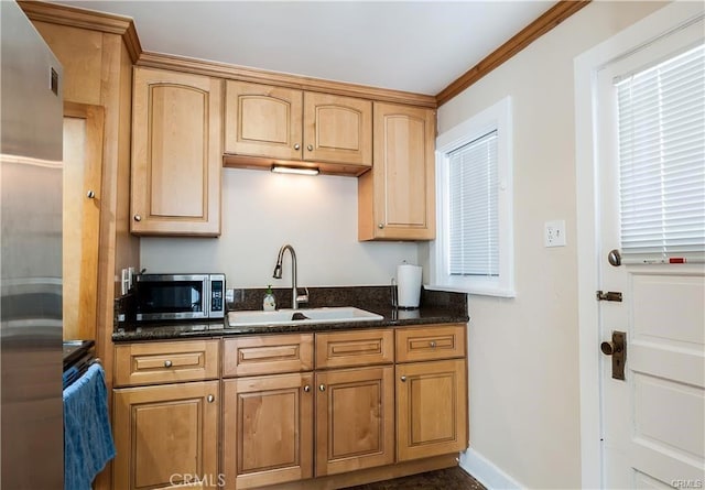 kitchen with crown molding, sink, light brown cabinets, and dark stone counters