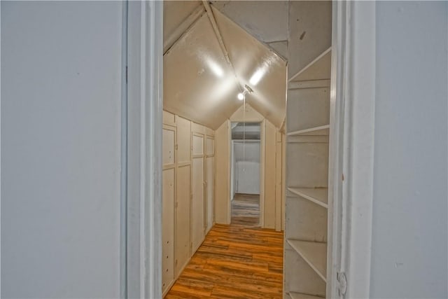 hallway featuring hardwood / wood-style flooring and lofted ceiling