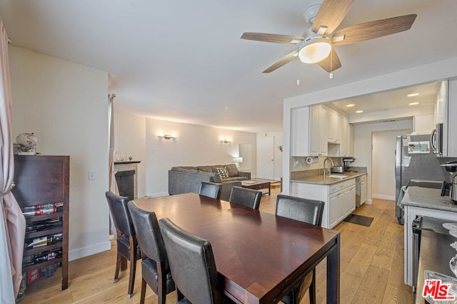 dining space featuring ceiling fan, sink, and light hardwood / wood-style floors