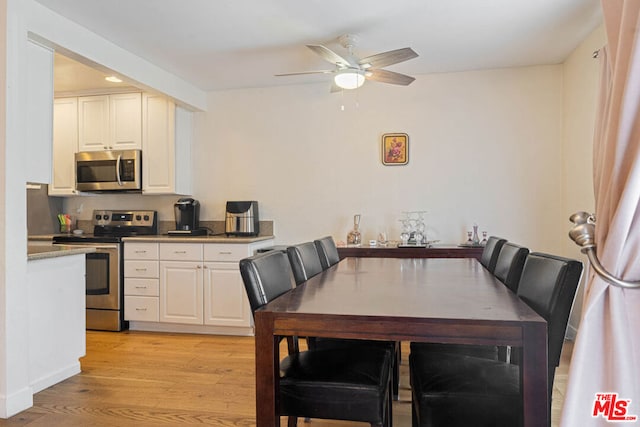 dining area with ceiling fan and light hardwood / wood-style floors