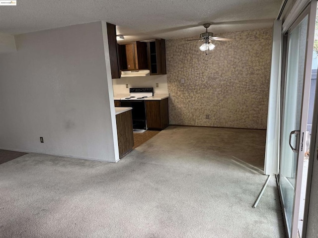 kitchen featuring electric stove, ceiling fan, light carpet, and a textured ceiling