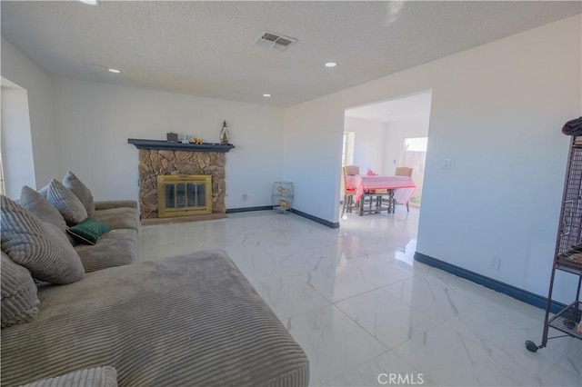 living room with a fireplace and a textured ceiling