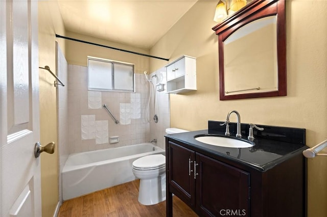 full bathroom featuring vanity, tiled shower / bath combo, wood-type flooring, and toilet