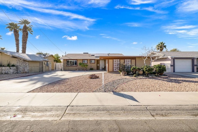 ranch-style home featuring a garage and solar panels