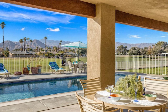 view of pool with a lawn, a mountain view, a jacuzzi, and a patio area