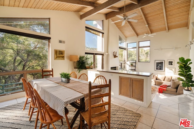 tiled dining space featuring wood ceiling, high vaulted ceiling, and beamed ceiling