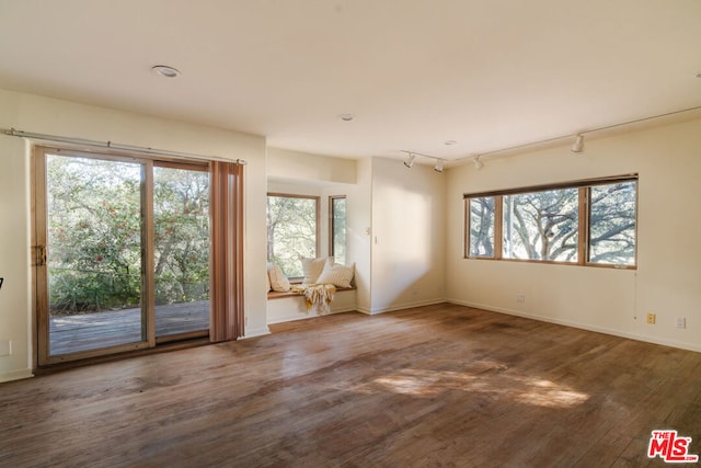 spare room with rail lighting and hardwood / wood-style floors