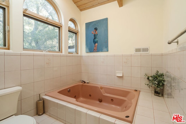 bathroom featuring tile patterned floors, a tub, and toilet