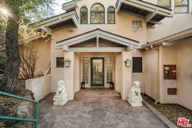 view of exterior entry featuring a patio area