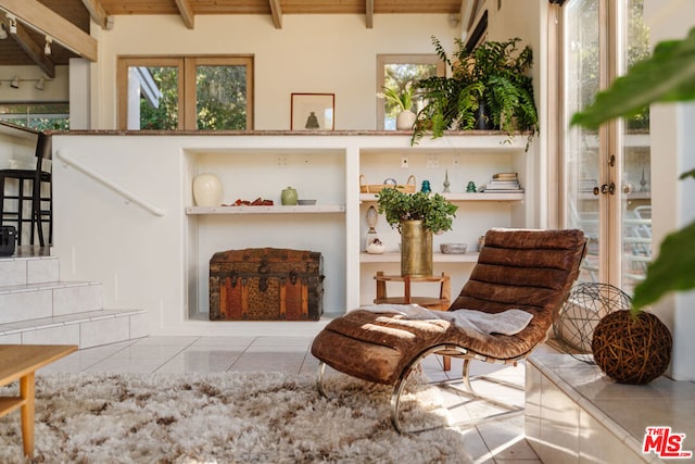 sitting room featuring wood ceiling, tile patterned floors, and beam ceiling