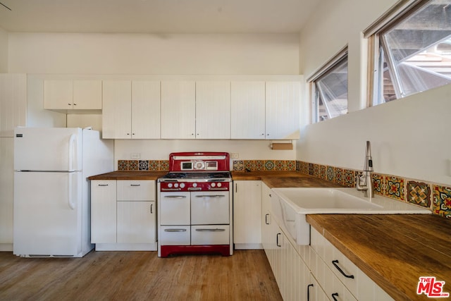 kitchen featuring double oven range, butcher block countertops, white fridge, and light hardwood / wood-style flooring