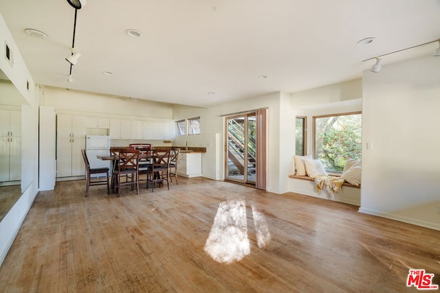 unfurnished dining area featuring light hardwood / wood-style floors and rail lighting