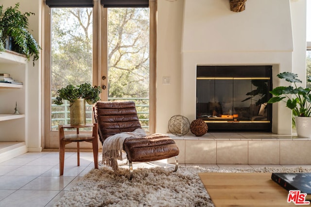 sitting room with light tile patterned floors and built in shelves