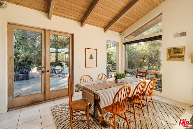 tiled dining area featuring beamed ceiling, a healthy amount of sunlight, french doors, and wooden ceiling