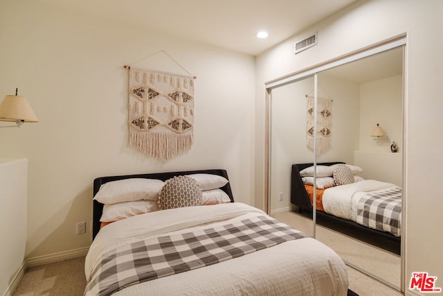 bedroom featuring light colored carpet and a closet